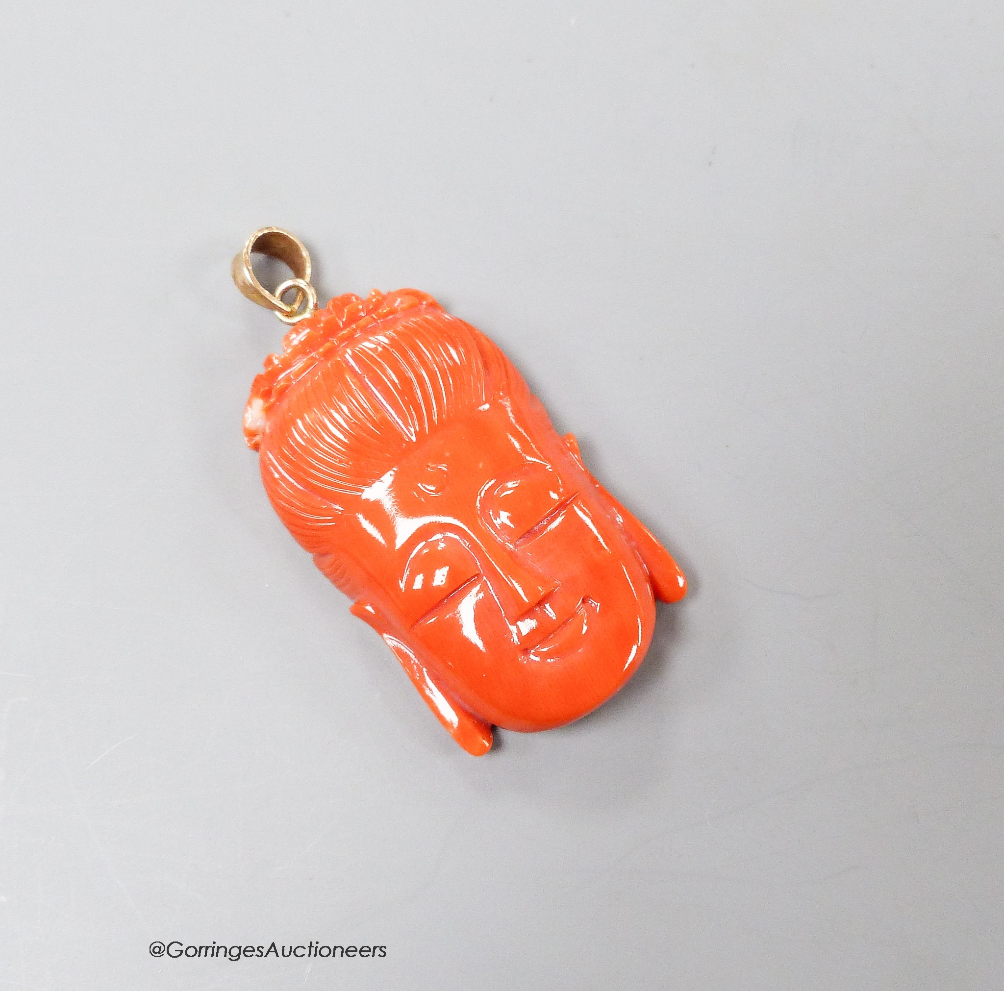 A Chinese 14k yellow metal mounted carved coral pendant, 35mm, gross weight 8.9 grams.